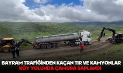 Bayram trafiğinden kaçan tır ve kamyonlar köy yolunda çamura saplandı