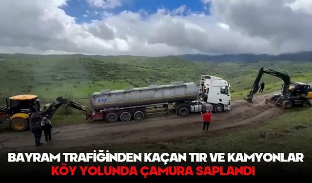 Bayram trafiğinden kaçan tır ve kamyonlar köy yolunda çamura saplandı